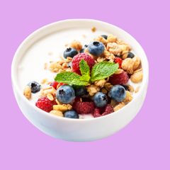 A CD Yogurt cup piled high with fresh raspberries, blueberries, granola and mint
